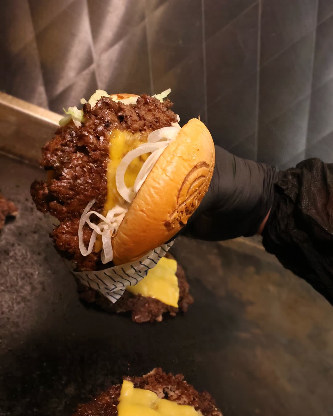 Stacked burger with melted cheese and pickles