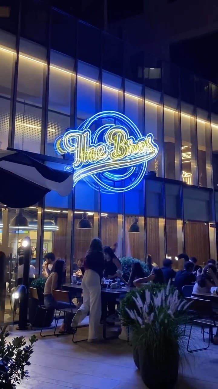 The Bros at night with neon sign